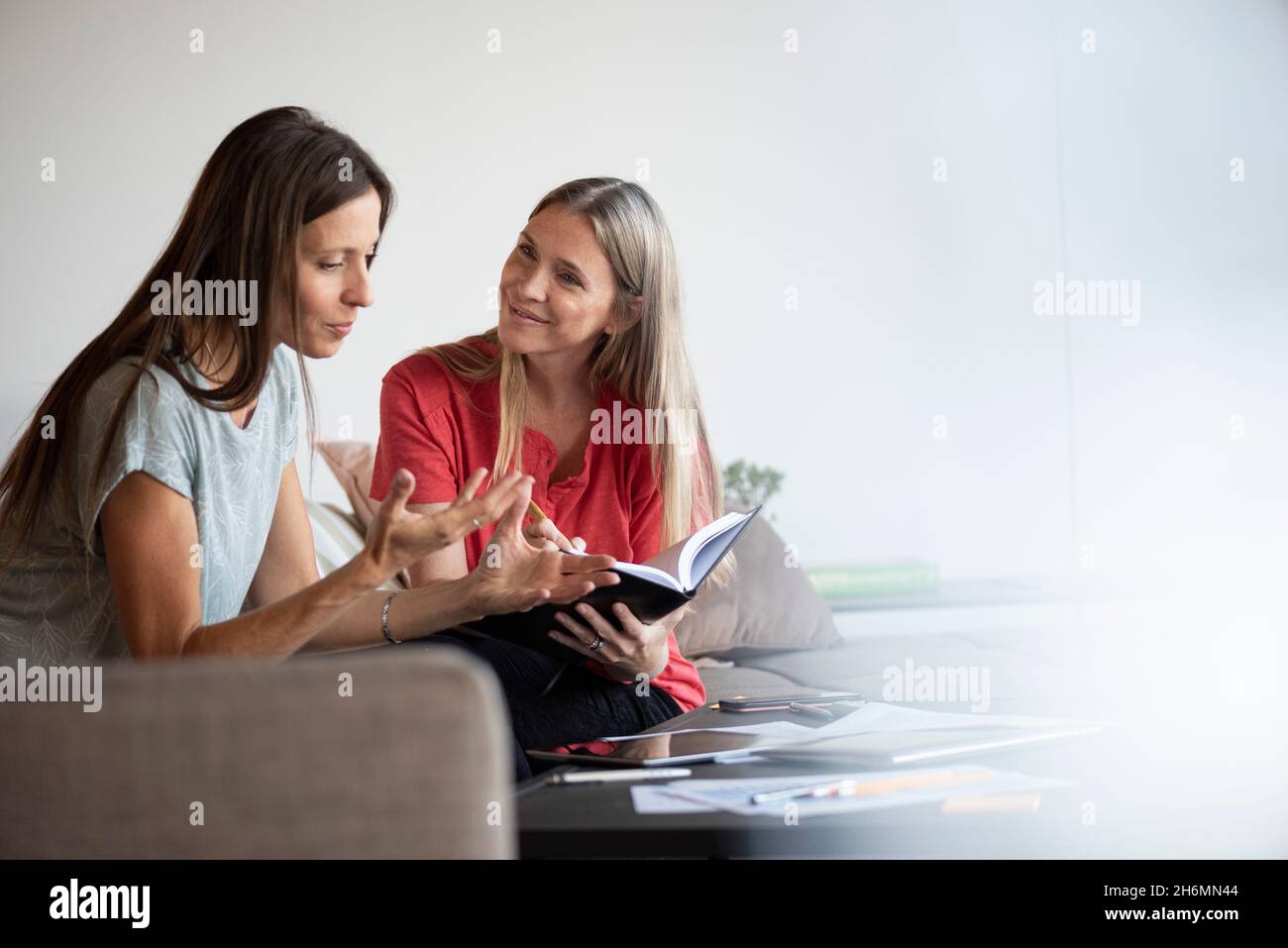 Femmes d'affaires souriantes travaillant sur une tablette numérique Banque D'Images