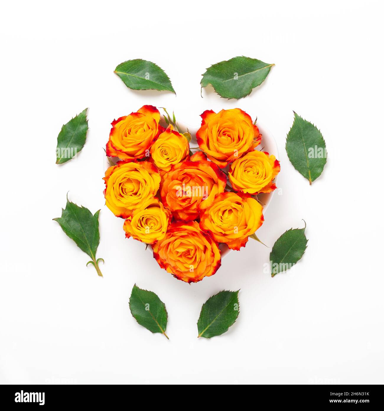 Composition des fleurs. Fleurs roses orange dans un bol en forme de coeur sur fond blanc. Concept de la Saint-Valentin. Flat lay, vue de dessus, espace de copie - image Banque D'Images