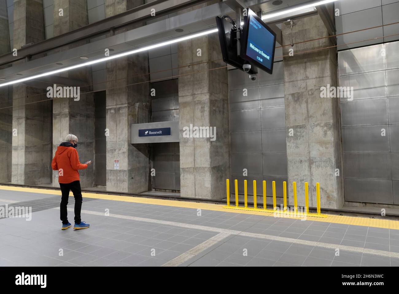 Un passager utilise son téléphone cellulaire en attendant le prochain train à la nouvelle station Link Light Rail Roosevelt à Seattle, le mardi 16 novembre 20 Banque D'Images
