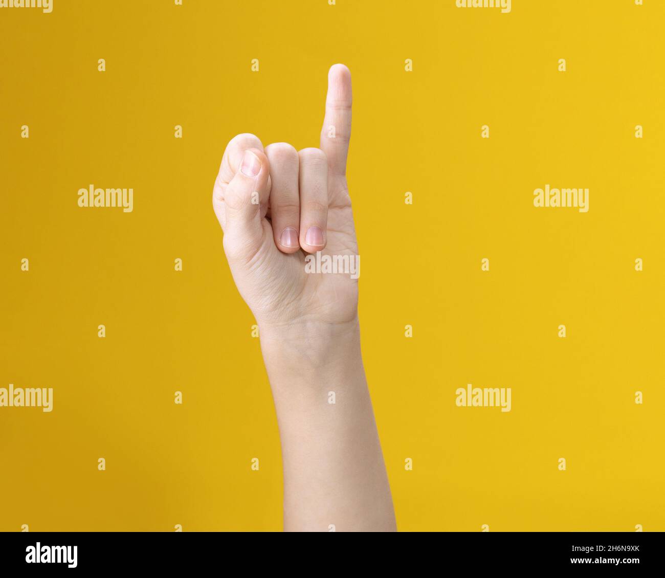 Image partielle d'une personne montrant un petit geste du doigt sur fond jaune Banque D'Images