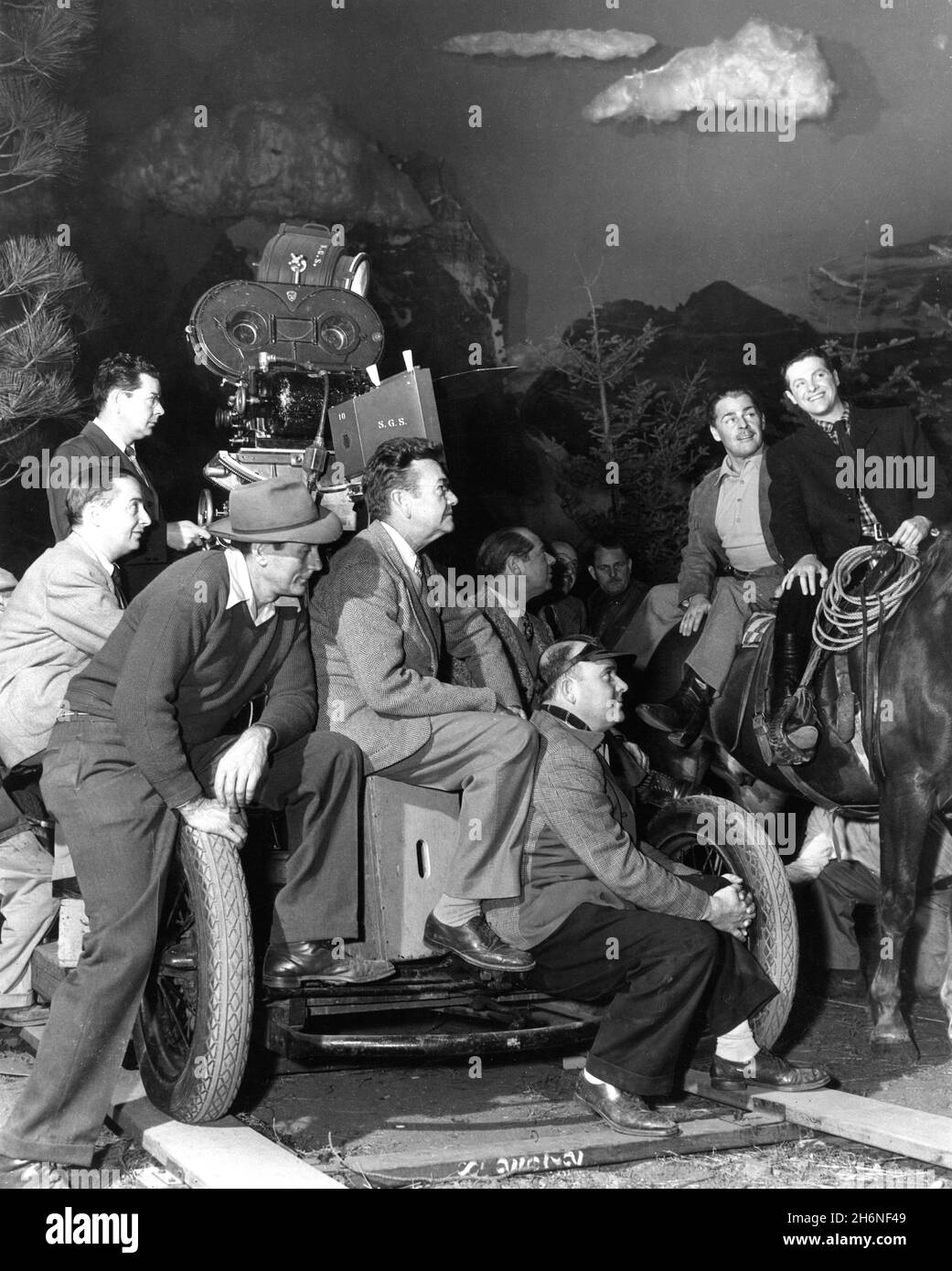 BRIAN DONLEVY et ROBERT CUMMINGS sur le plateau Candid avec Camera / Movie Crew y compris le cinéaste KARL STRUSS (au centre) pendant le tournage du CIEL NE CONNAÎT QUE 1947 réalisateur ALBERT S. ROGELL Nero films / United Artists Banque D'Images