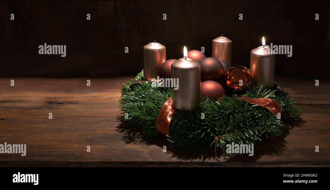 Deuxième couronne de l'Avent avec bougies couleur cuivre et boules de Noël sur une table rustique en bois sur fond brun foncé, panoramique Banque D'Images