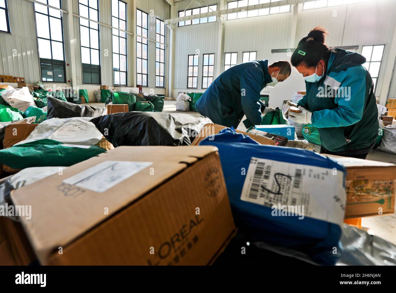 Zhangye, Zhangye, Chine.17 novembre 2021.Le 16 novembre 2021, le centre de tri postal express de Zhangye City, province de Gansu, le personnel de livraison trient express, prêt à livrer rapidement aux clients.Le même jour, Zhangye, Gansu a repris son service de livraison postale.Des sociétés express comme Zhangye City Post Express et Shunfeng ont effectué une désinfection stricte des véhicules pour plus de 300,000 colis express bloqués à Lanzhou, des codes de test de température du personnel, la prévention et l'élimination des épidémies de courrier express et la traçabilité.Après identification et inspection et othe Banque D'Images