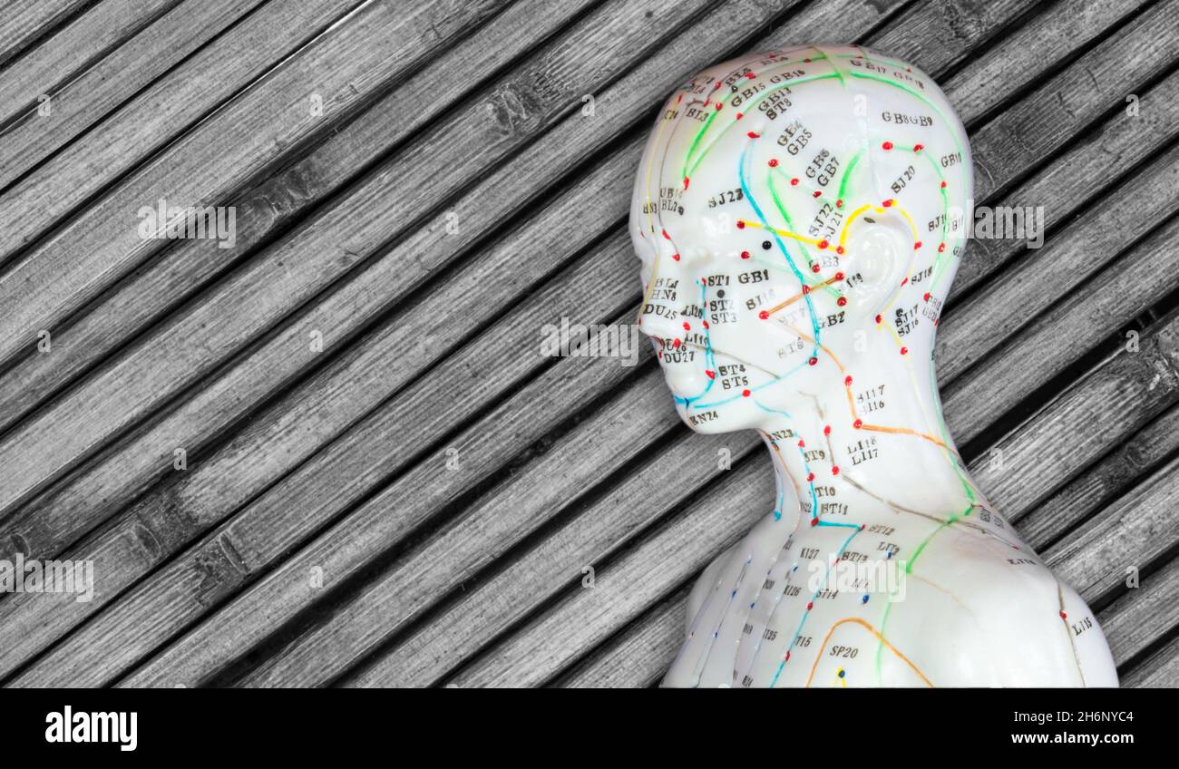 Méridiens acupuncture sur un modèle de corps humain sur un fond en bois Banque D'Images