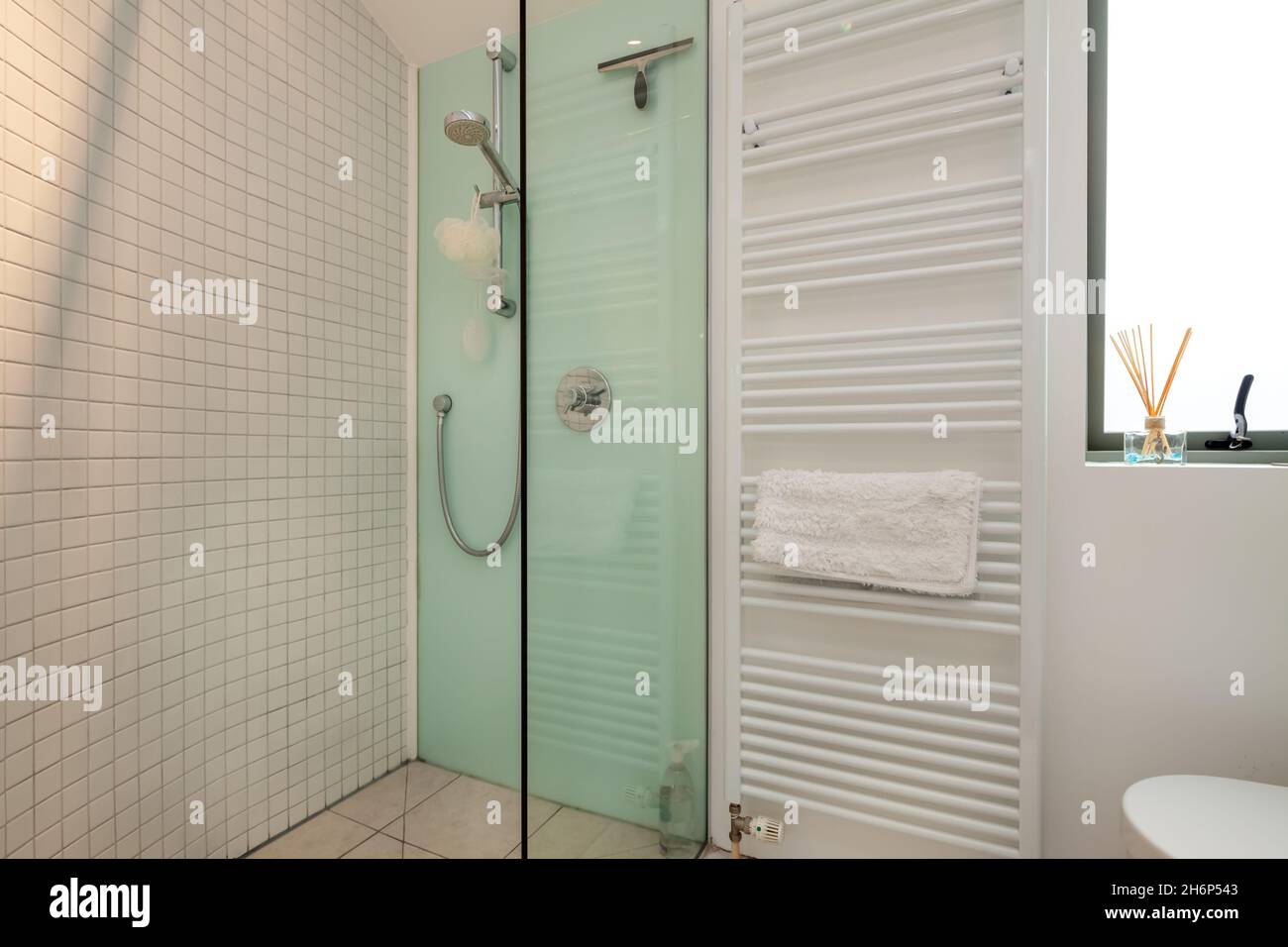 Clare, Angleterre - Mars 9 2020: Salle de douche domestique résidentielle avec partie carrelée et armoire vitrée en blanc et vert Banque D'Images