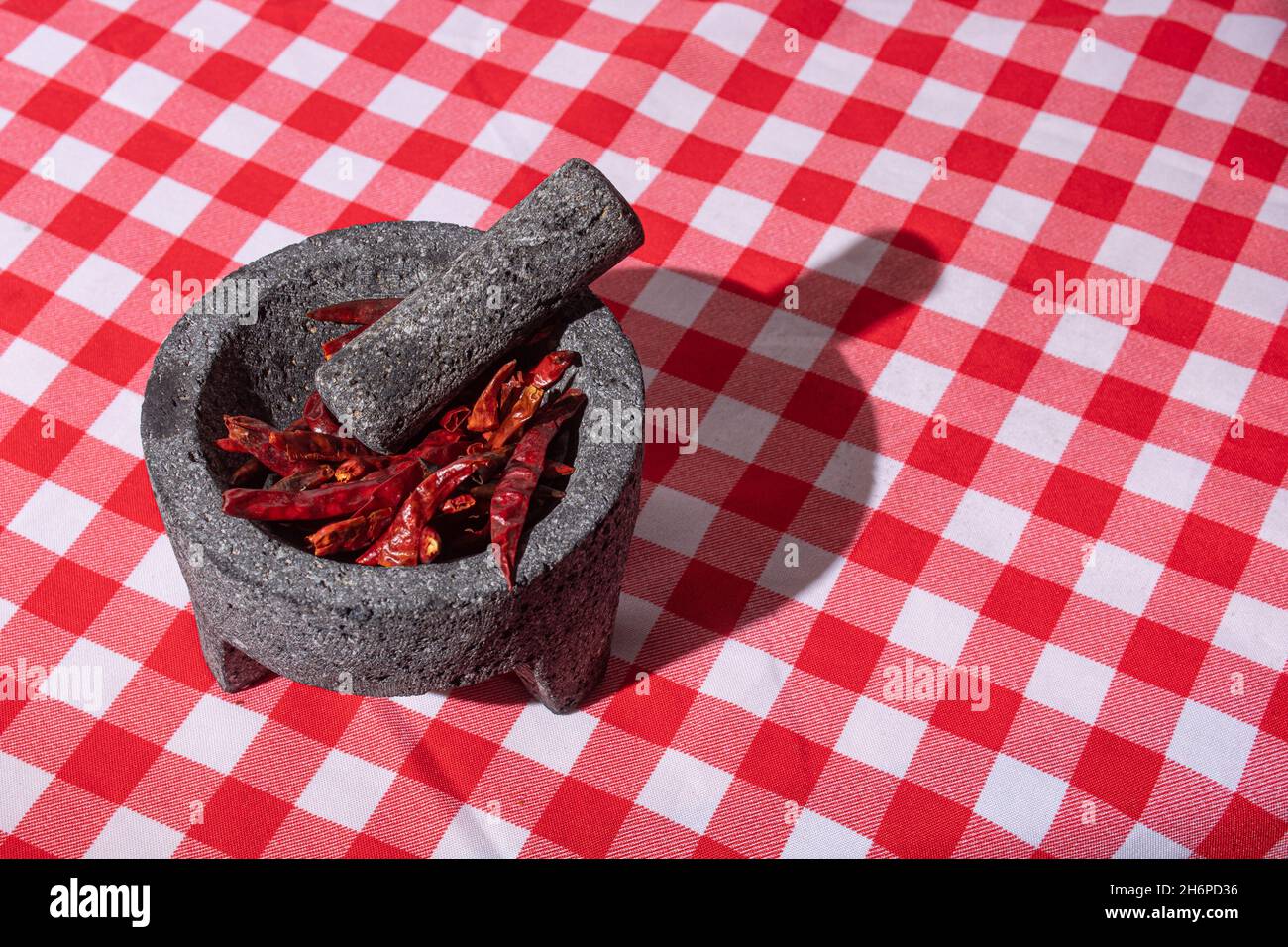Gros plan de piment rouge séché avec mortier et pilon. Banque D'Images
