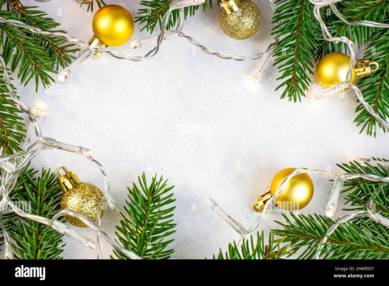 Branches de sapin vert, boules dorées et lumières en tant que décorations saisonnières de Noël sur fond blanc pour cartes de vœux avec espace pour les copies.CH. Traditionnel Banque D'Images