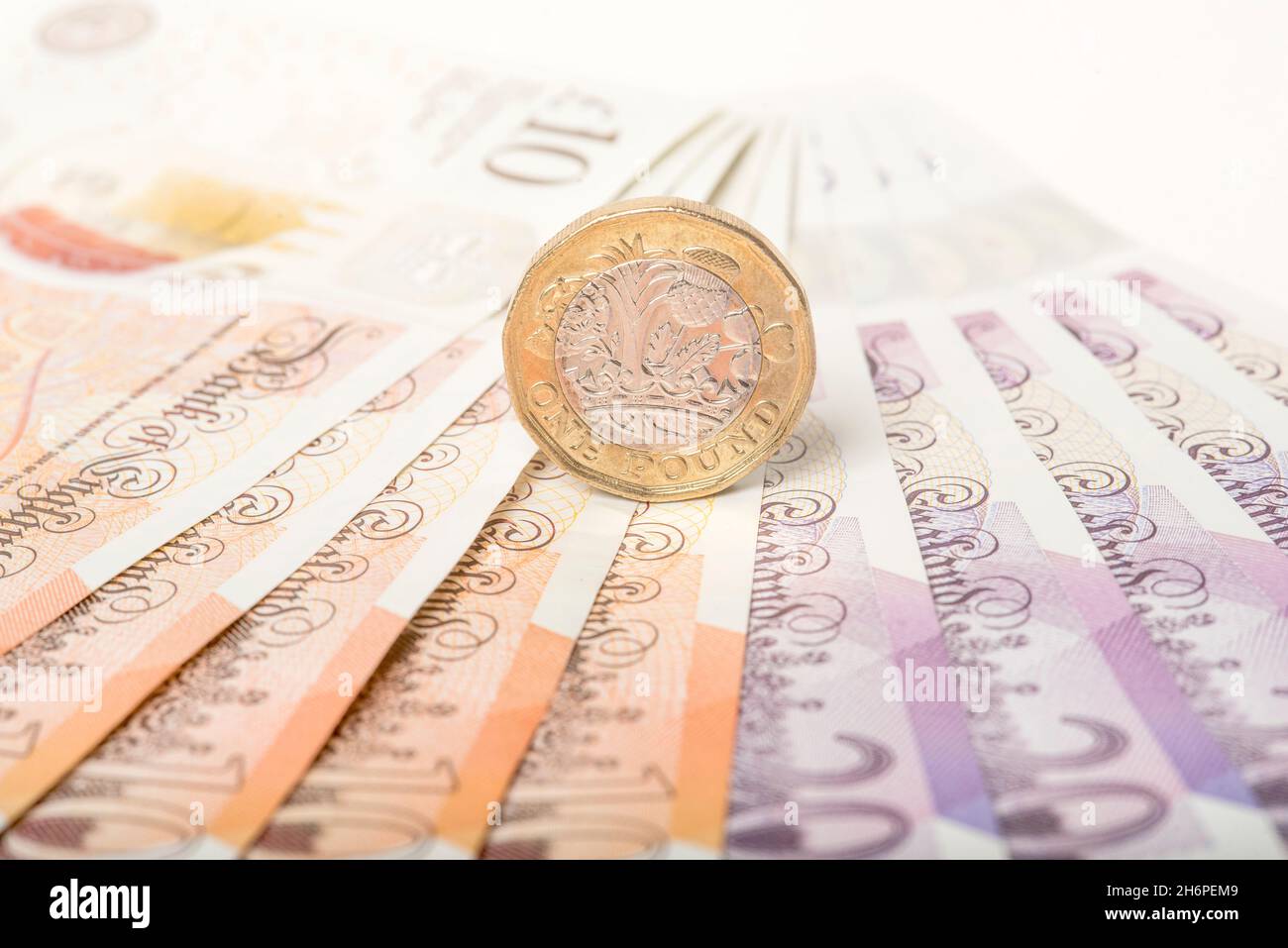 Argent: Une et deux pièces de livre se sont assis sur des billets de dix et vingt livres.£1 £10 £20 Livre Sterling devise.Gros plan, arrière-plan. Banque D'Images