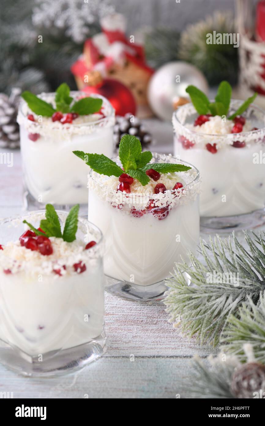 Mojito de Noël blanc à base de liqueur, tequila, lait de coco aux graines de grenade, flocons de noix de coco et menthe rafraîchissante. Banque D'Images