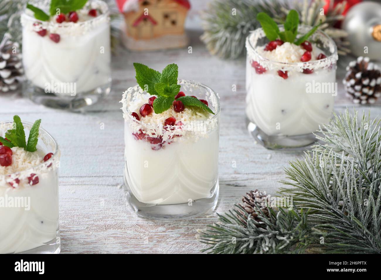 Mojito de Noël blanc à base de liqueur, tequila, lait de coco aux graines de grenade, flocons de noix de coco et menthe rafraîchissante. Banque D'Images