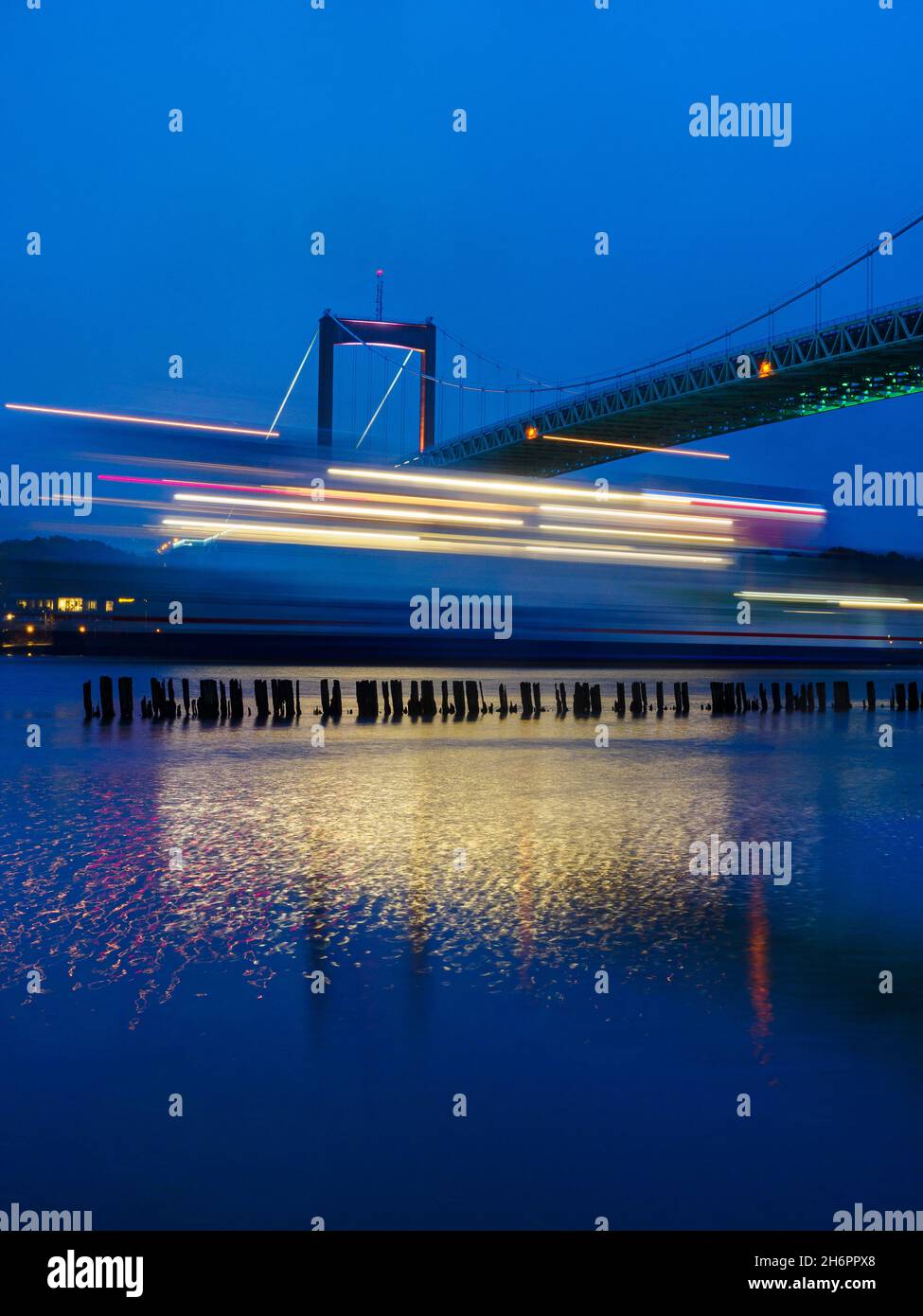 Ferry passant le pont à la lumière du soir Banque D'Images