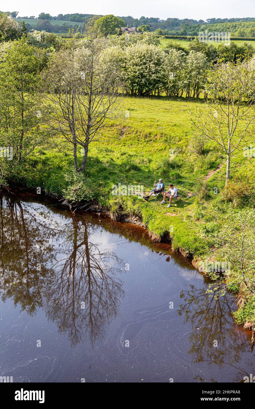 Pêcheurs à la ligne pêchant dans la rivière Irthing à côté du vieux pont à Lanercost, Cumbria Royaume-Uni Banque D'Images