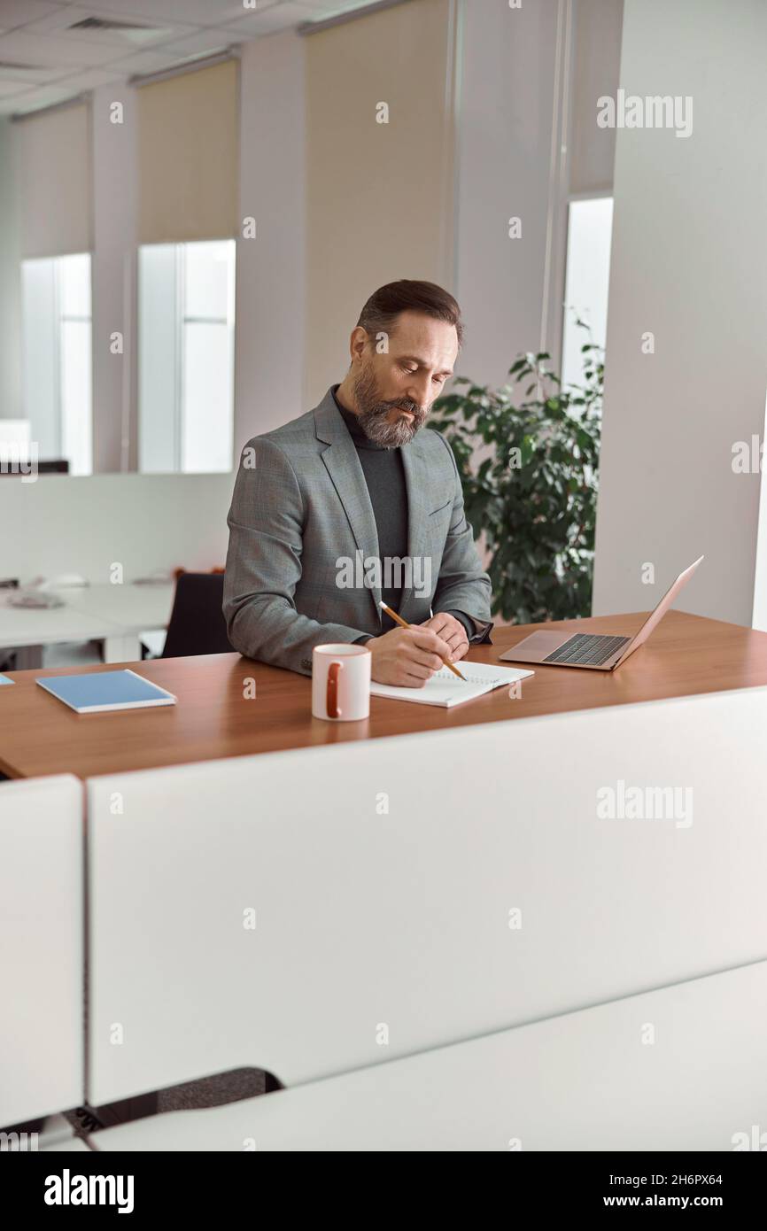 Un homme de race blanche, un adulte heureux, travaille dans un bureau moderne Banque D'Images