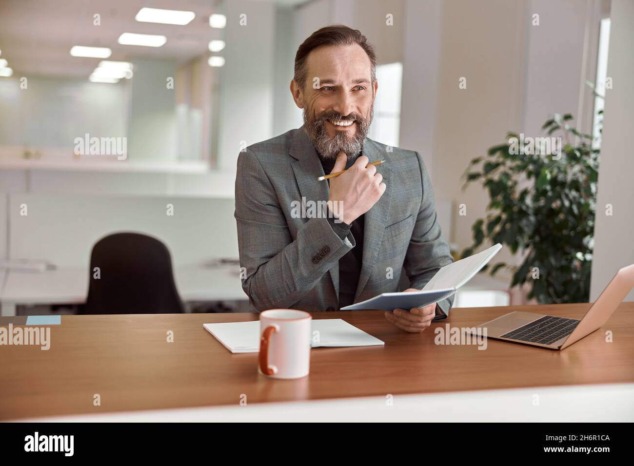 Un homme de race blanche, un adulte heureux, travaille dans un bureau moderne Banque D'Images