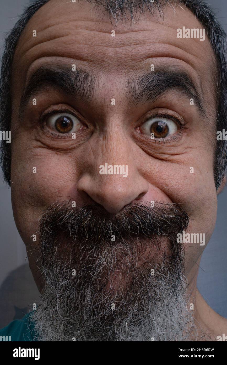 Homme caucasien d'âge moyen avec bouc faisant des visages drôles à la caméra Banque D'Images