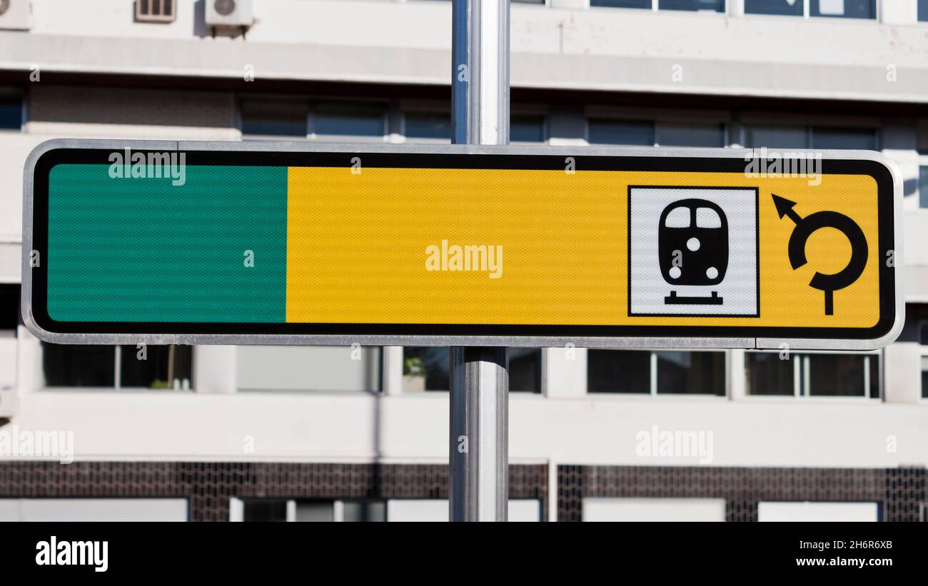 Panneau vierge jaune et vert réfléchissant pour la gare routière sur la rue.Arrière-plan de trafic vide pour le texte. Banque D'Images