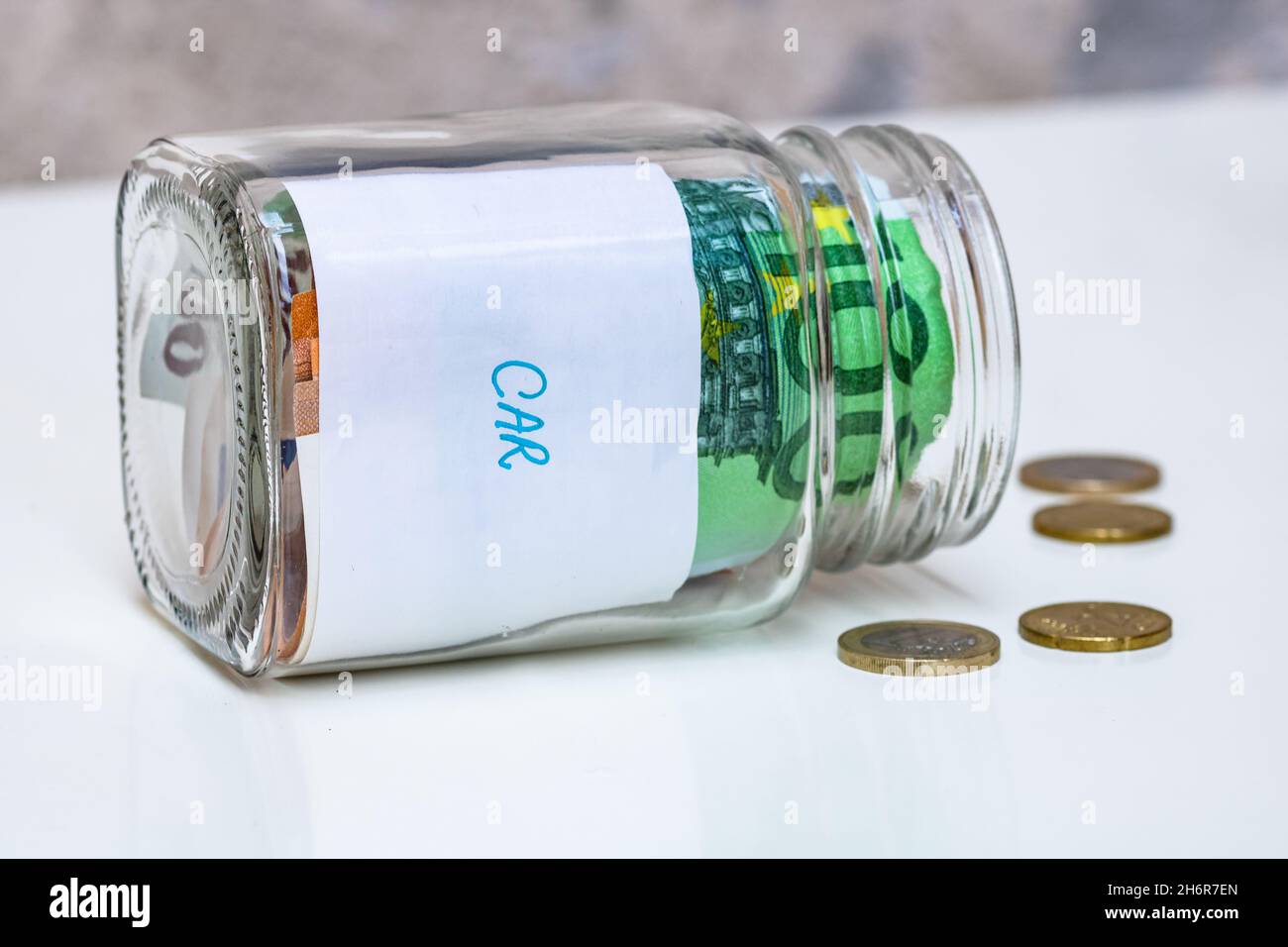 Gros plan des billets de banque dans un pot en verre avec texte voiture neuve.Concept d'investissement et de conservation de l'argent Banque D'Images