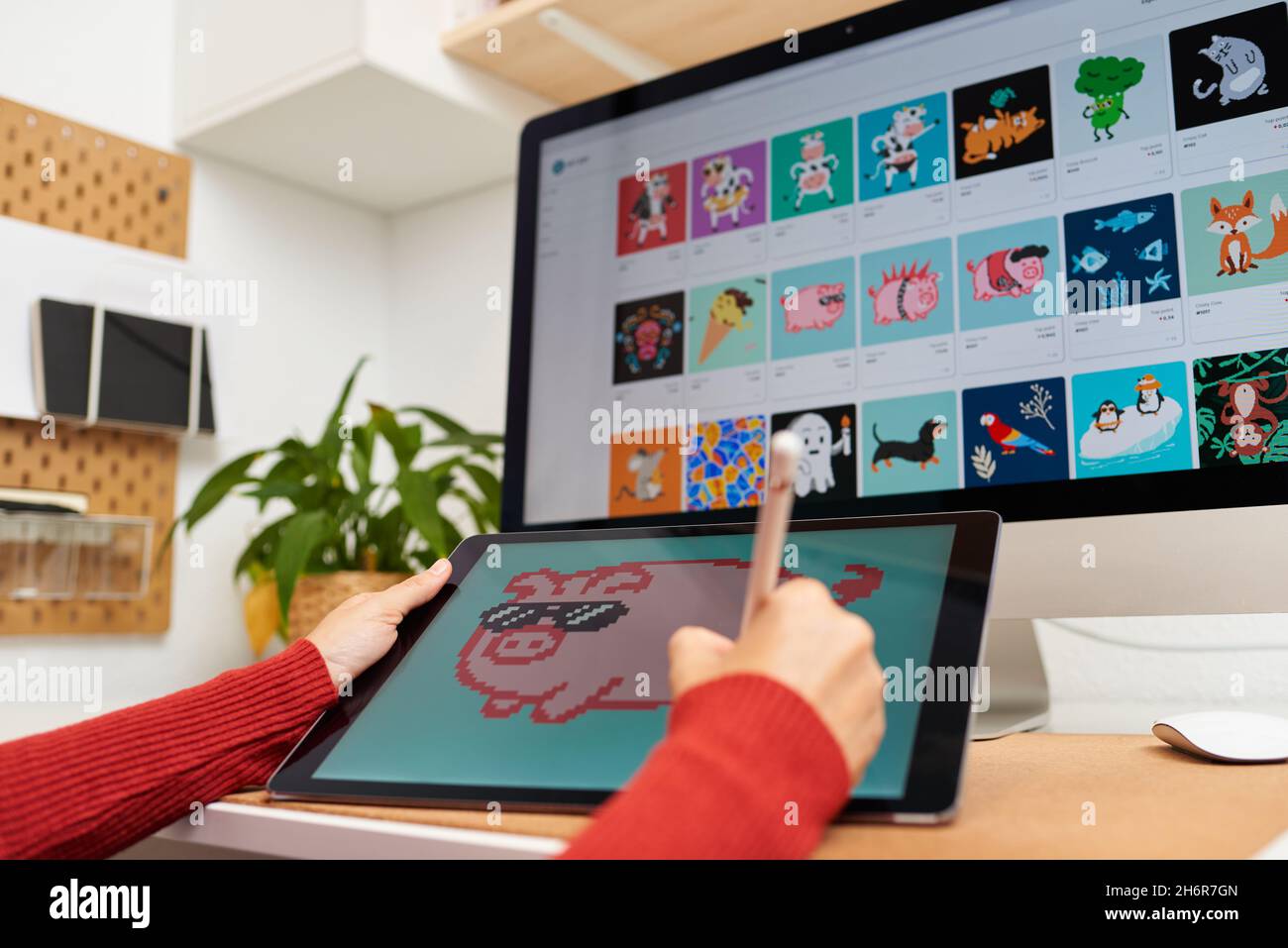 Artiste NFT peint sur une tablette numérique dans son bureau à domicile Banque D'Images