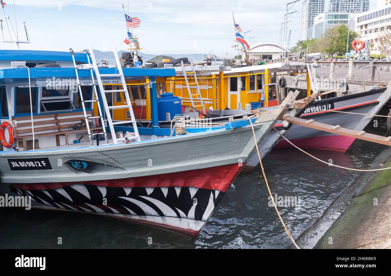 Kota Kinabalu, Malaisie - 23 mars 2019 : bateaux de pêche colorés amarrés près du marché aux poissons KK par une journée ensoleillée Banque D'Images