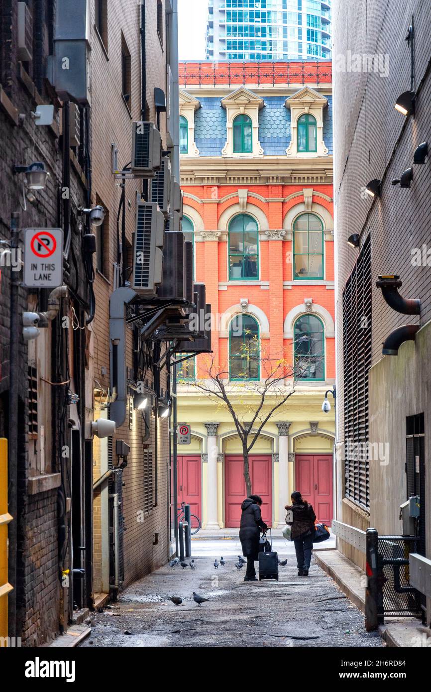 Les gens qui marchent dans une allée avec des vieux bâtiments de style colonial en arrière-plan dans le quartier du centre-ville de Toronto, Canada.17 novembre 2021 Banque D'Images