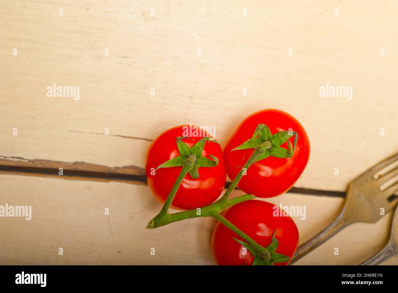 Tomates cerise mûre sur cluster tableau rustique en bois blanc Banque D'Images