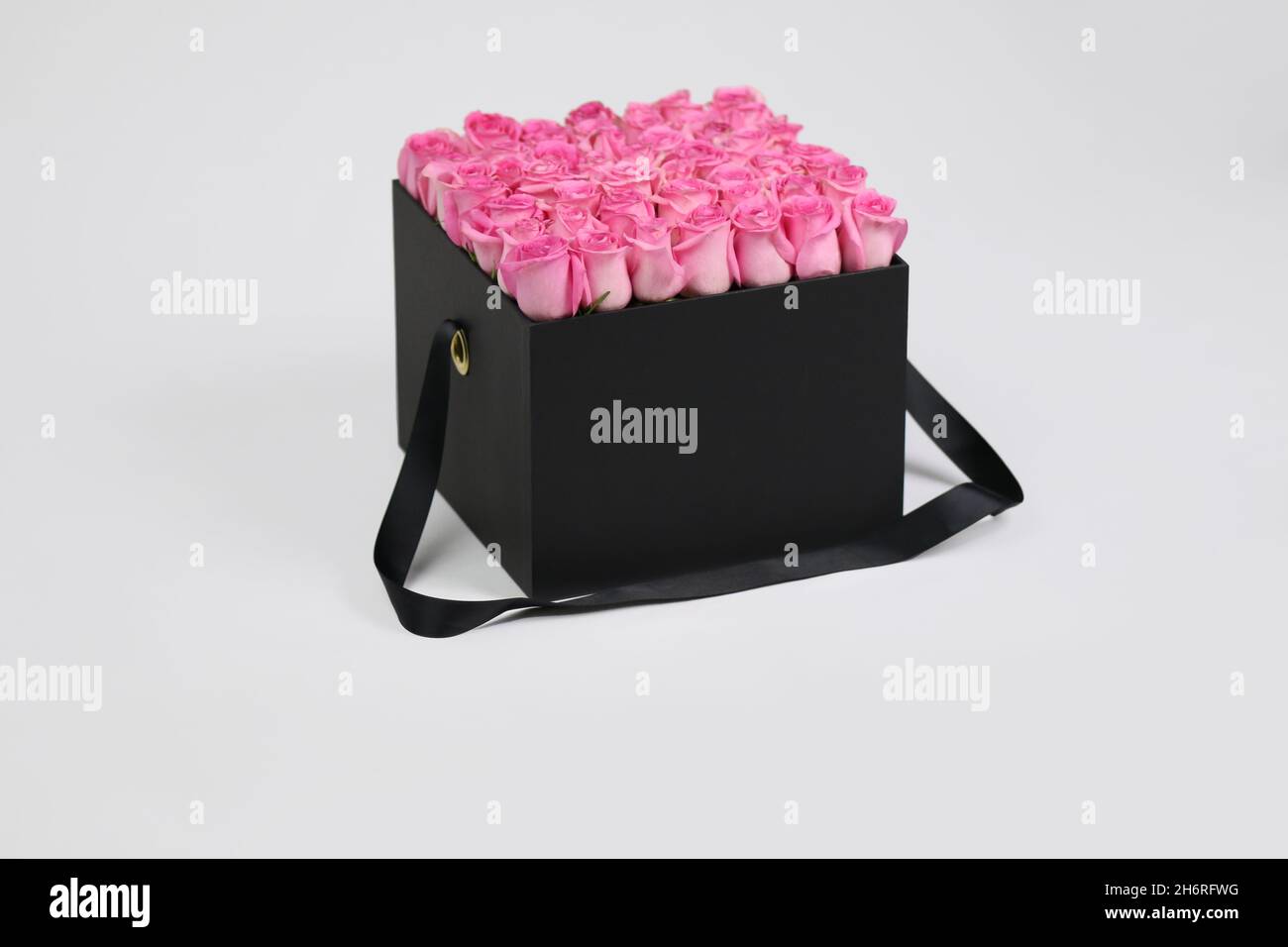 Boîte cadeau à fleurs carrée noire avec roses roses à l'intérieur.Agencement fleuri élégant. Banque D'Images