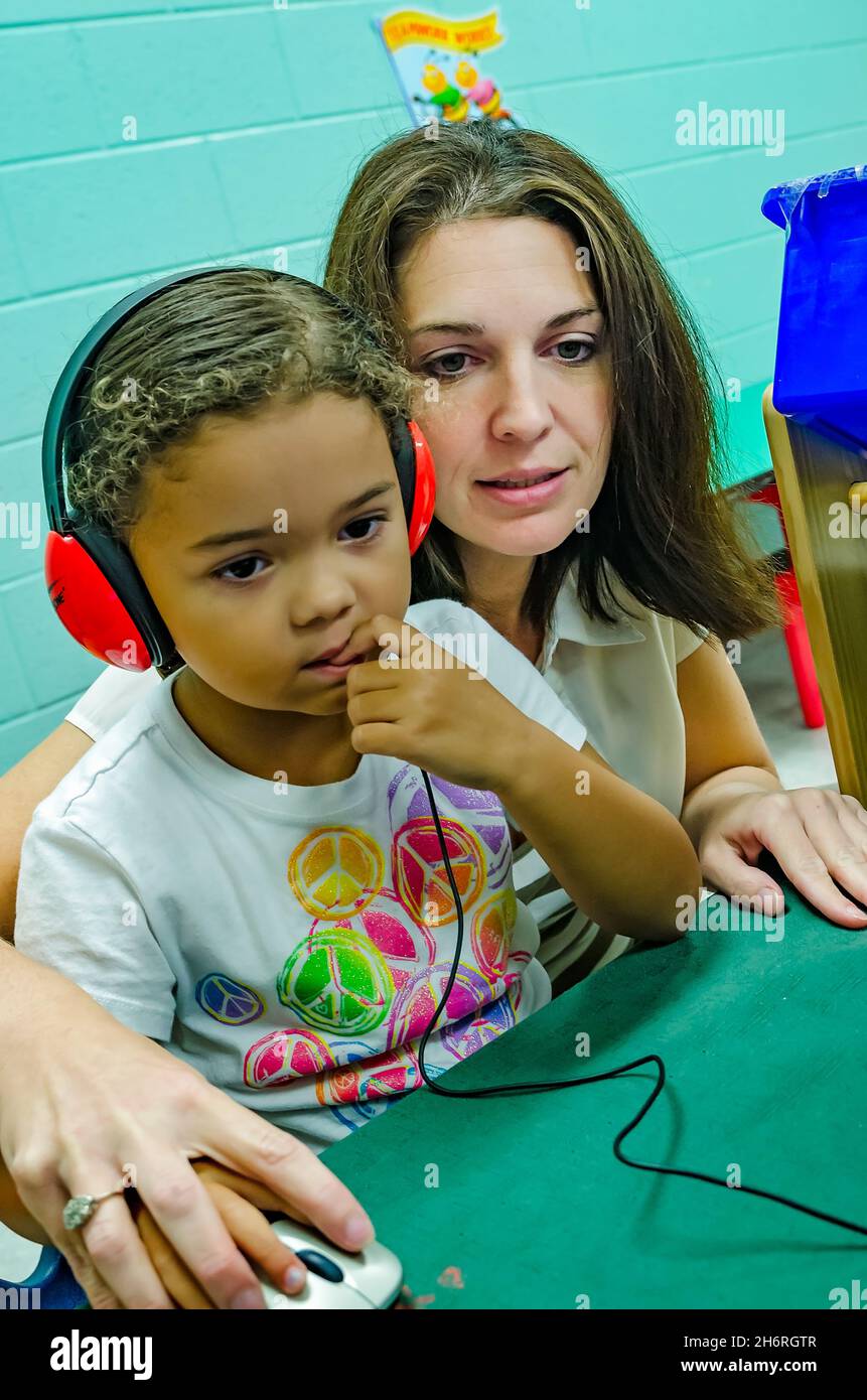 Un professeur de pré-maternelle aide un étudiant à jouer un jeu d'ordinateur pour apprendre les couleurs, 13 août 2012, à Columbus, Mississippi. Banque D'Images