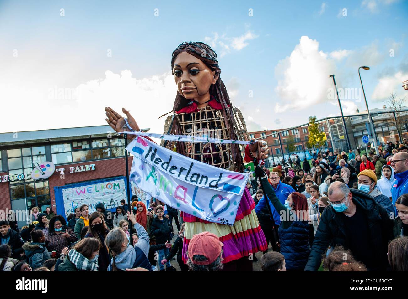 La Haye, pays-Bas.17 novembre 2021.Little Amal reçoit une bannière accueillante.Amare, un nouveau centre culturel au centre de la Haye, a organisé dans le cadre de son « Open Festival », la visite de la marionnette géante « Little Amal », une jeune fille réfugiée syrienne de neuf ans et de plus de 11 mètres de hauteur au théâtre « de Vaillant »,Connue pour sa diversité culturelle et dans le but d'accroître la participation culturelle de tous les habitants de la Haye.De là, le petit Amal accompagné d'enfants a marché et joué autour du quartier.Crédit : SOPA Images Limited/Ala Banque D'Images