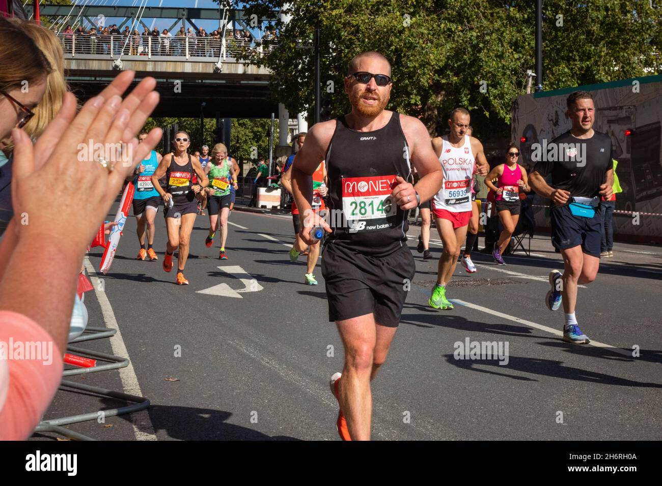Homme en train de courir avec des spectateurs, Virgin Money London Marathon 2021 au point de 25 miles, Victoria Embankment. Banque D'Images