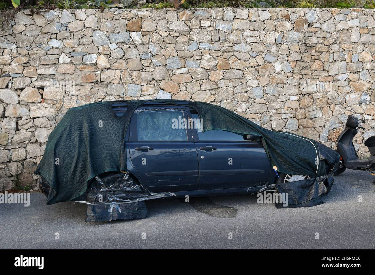 Couverture DIY pour une voiture garée pour la période des vacances d'été le long d'une route municipale dans la destination touristique d'Alassio, Savona, Ligurie, Italie Banque D'Images