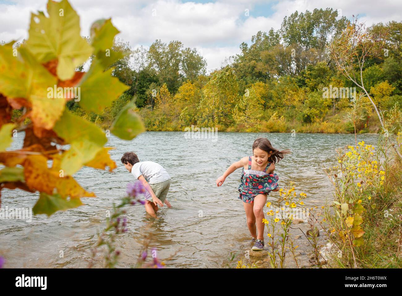 Deux petits enfants se réjouissent de se papas dans le lac par une journée venteuse en été Banque D'Images