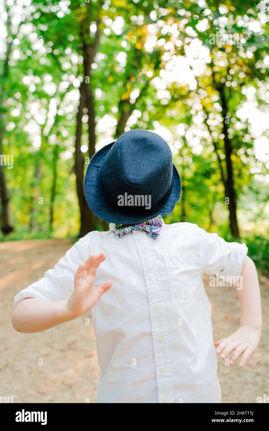 Portrait d'un jeune garçon jouant avec un chapeau sur son visage Banque D'Images