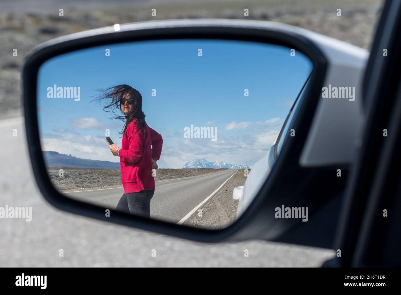 Femme traversant le parcours vu à travers le rétroviseur latéral de la voiture Banque D'Images