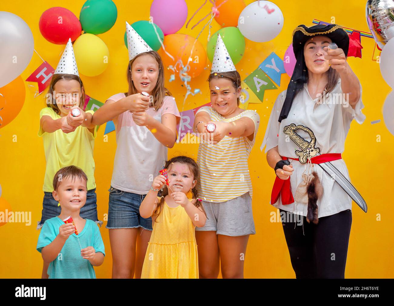 Enfants et pirate à la fête d'anniversaire sur fond jaune Banque D'Images