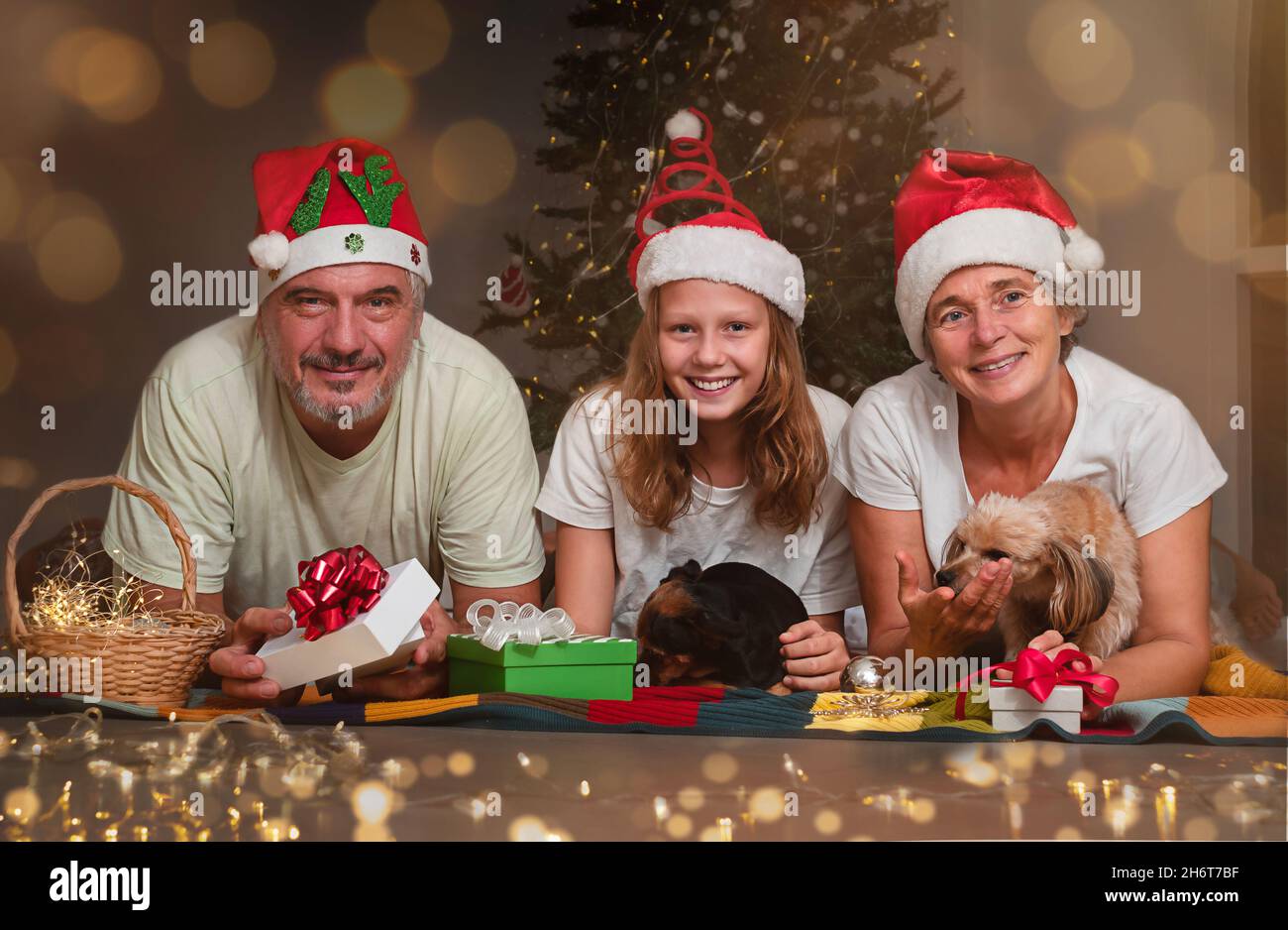 Un couple âgé avec un adolescent échange de cadeaux pour Noël.Portrait d'une famille heureuse près de l'arbre de noël Banque D'Images