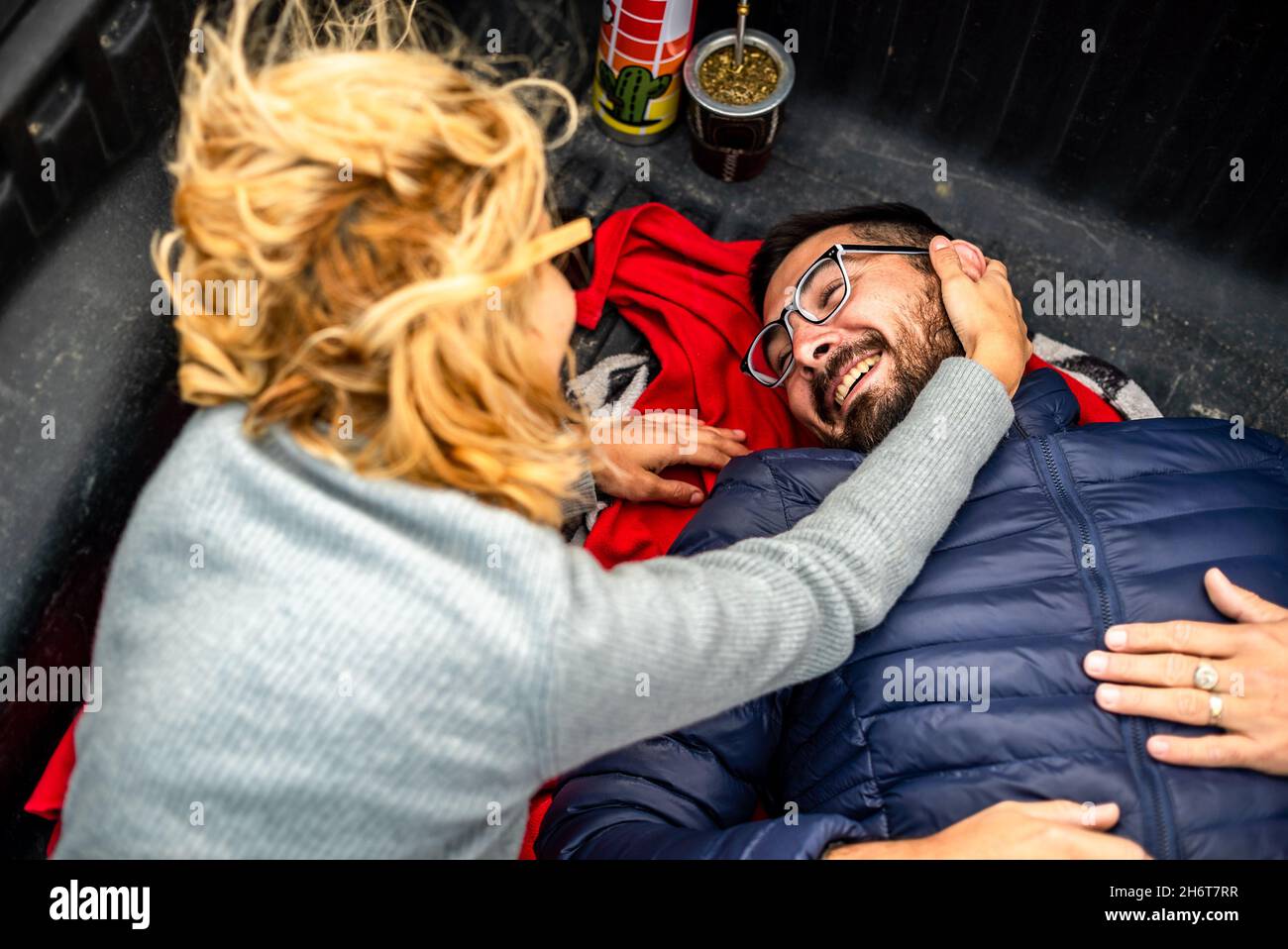 Charmant couple argentin adulte riant et se câliner sur un plateau de chargement d'une voiture de camion Banque D'Images