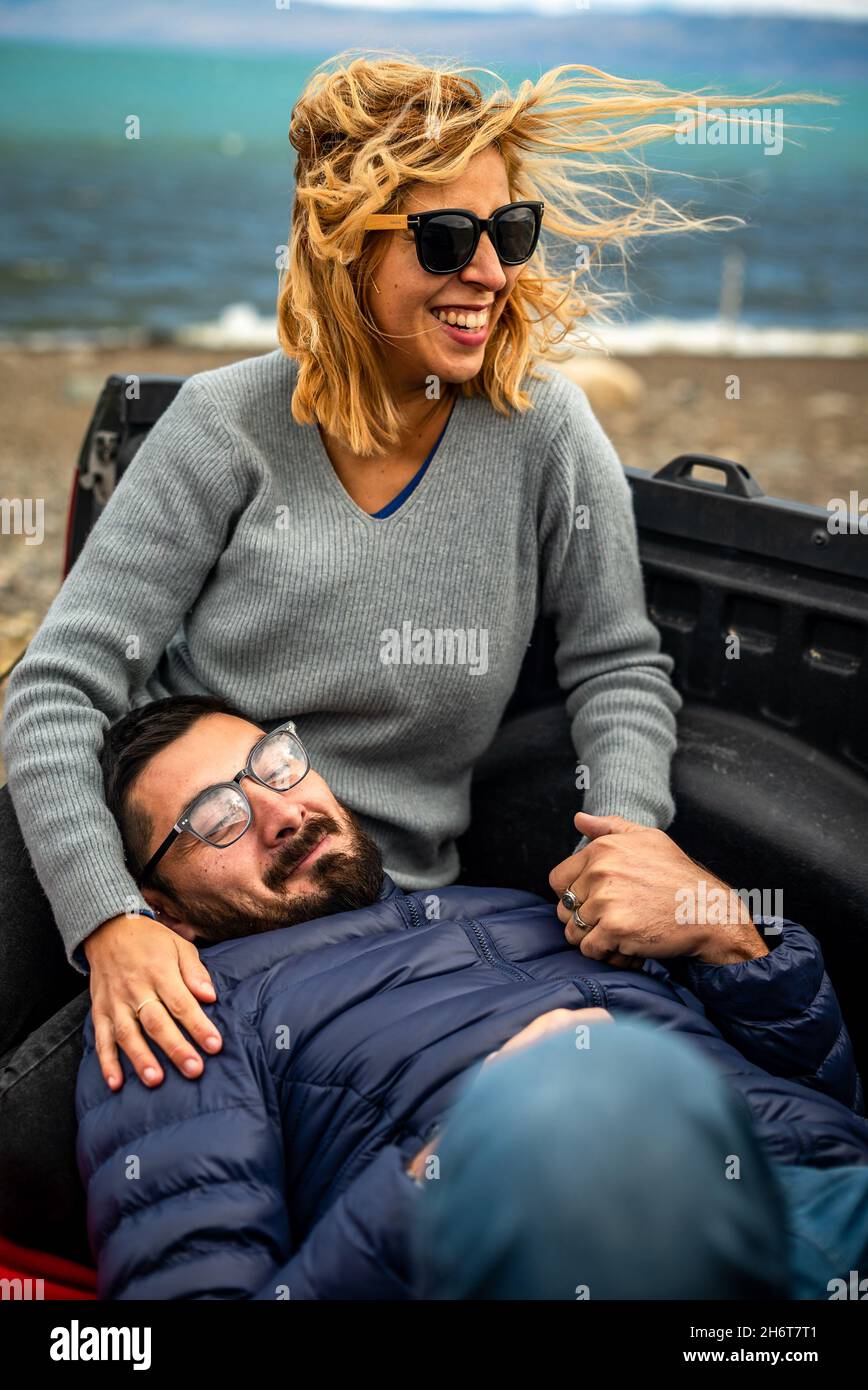 Adorable couple argentin adulte dans un lit cargo d'une voiture garée sur la plage Banque D'Images