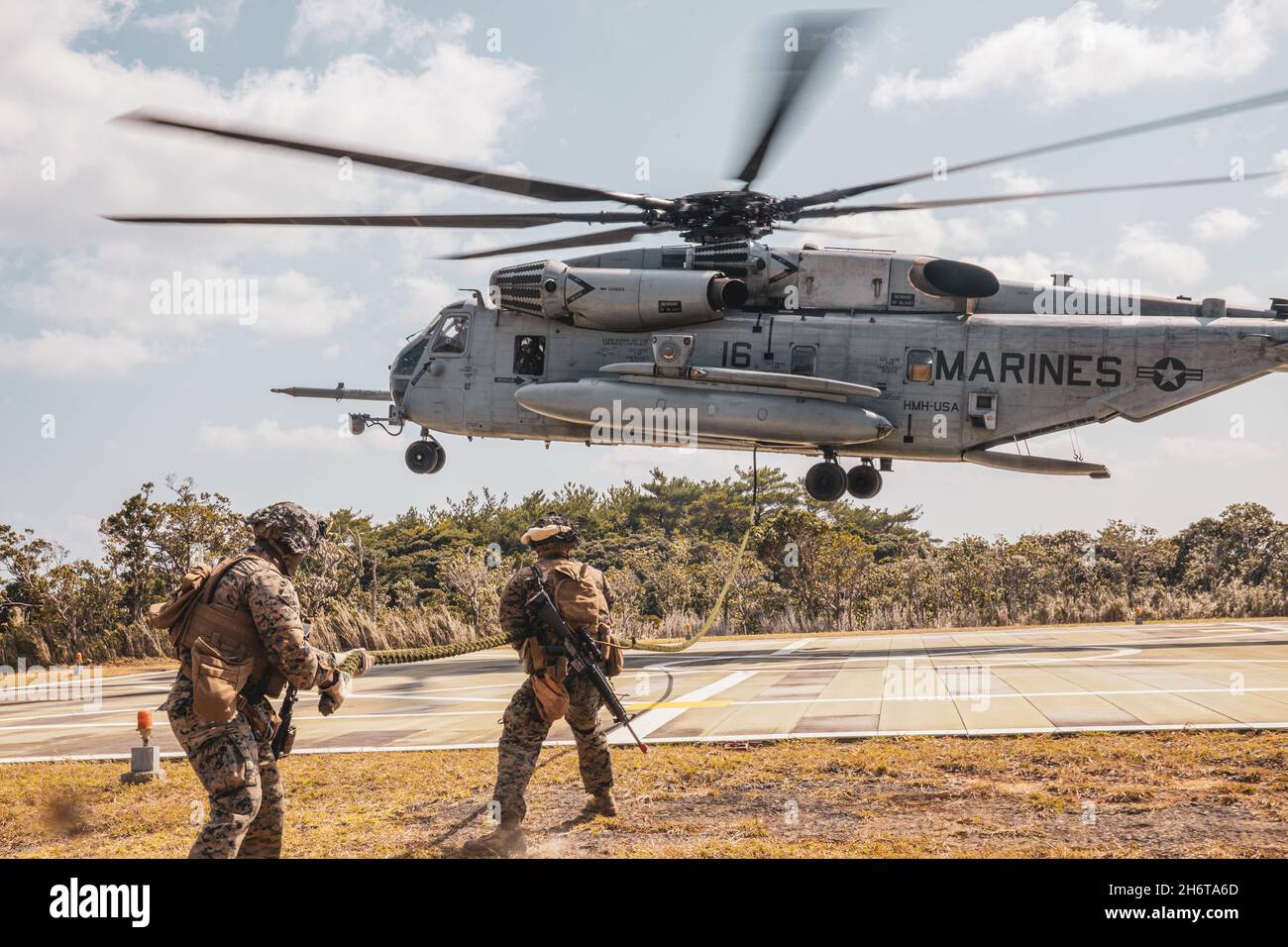 Sergent du corps des Marines des États-UnisDavid Edeh et lance Cpl.Michael Thollander, ingénieurs de combat de l'escadron de soutien de l'escadre Marine (MWSS) 172, 1re escadre d'aéronef Marine, tire le mou d'une corde après avoir rapidement roulé de l'hélicoptère CH-53E Super Stallion lors d'un exercice sur le terrain au Centre d'entraînement Jungle Warfare, Camp Gonsalves, Okinawa, Japon, 3 novembre,2021. MWSS-172 a tenu cet exercice afin de présenter une preuve de concept pour les ascenseurs externes, de s'appuyer sur le concept Expeditionary Advanced base Operations et d'améliorer l'efficacité de combat de la compagnie d'ingénieur dans un environnement de guerre expéditionnaire dans la jungle Banque D'Images