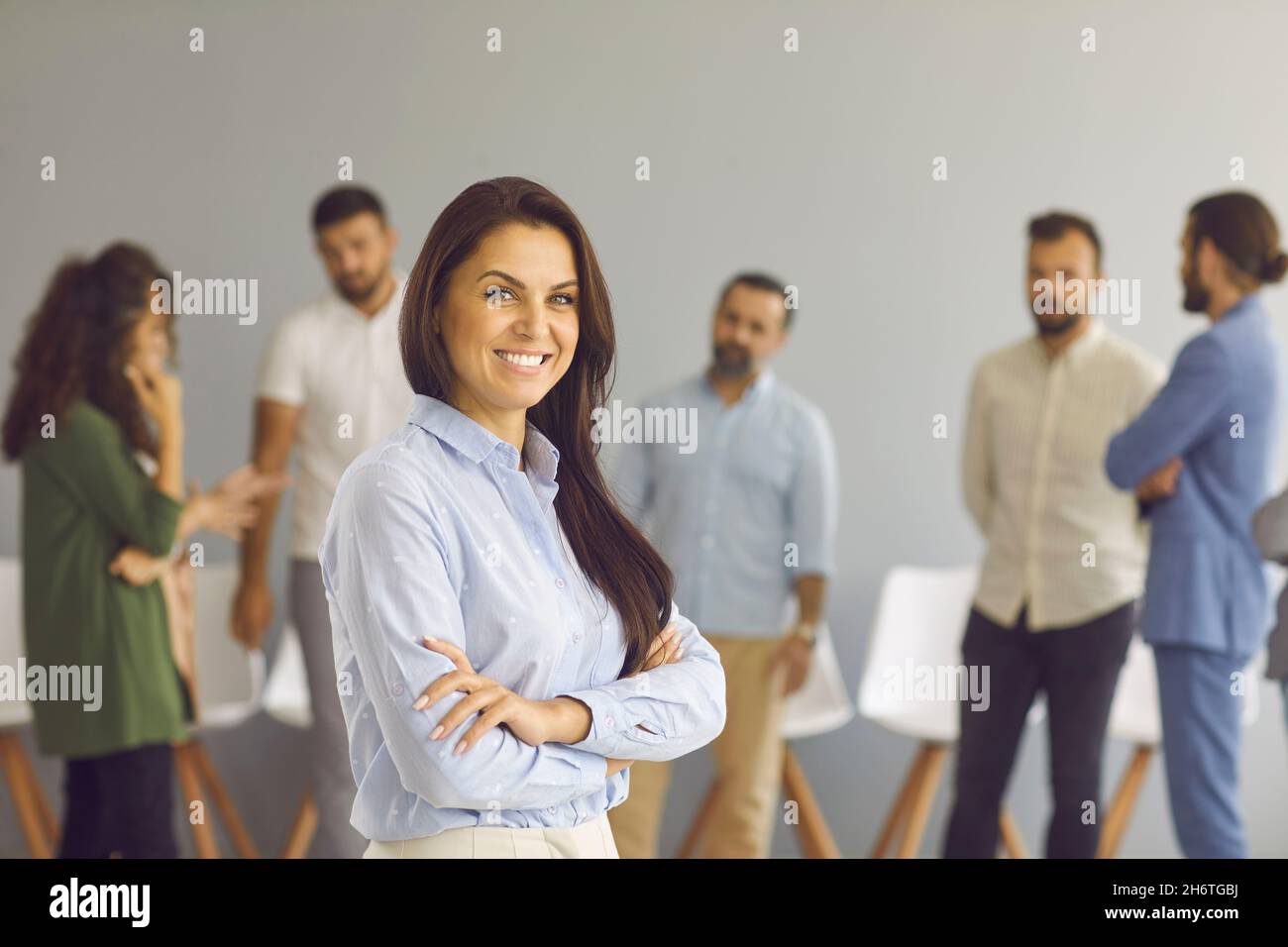 Portrait d'une femme d'affaires réussie debout dans la salle de bureau sur le fond des employés. Banque D'Images