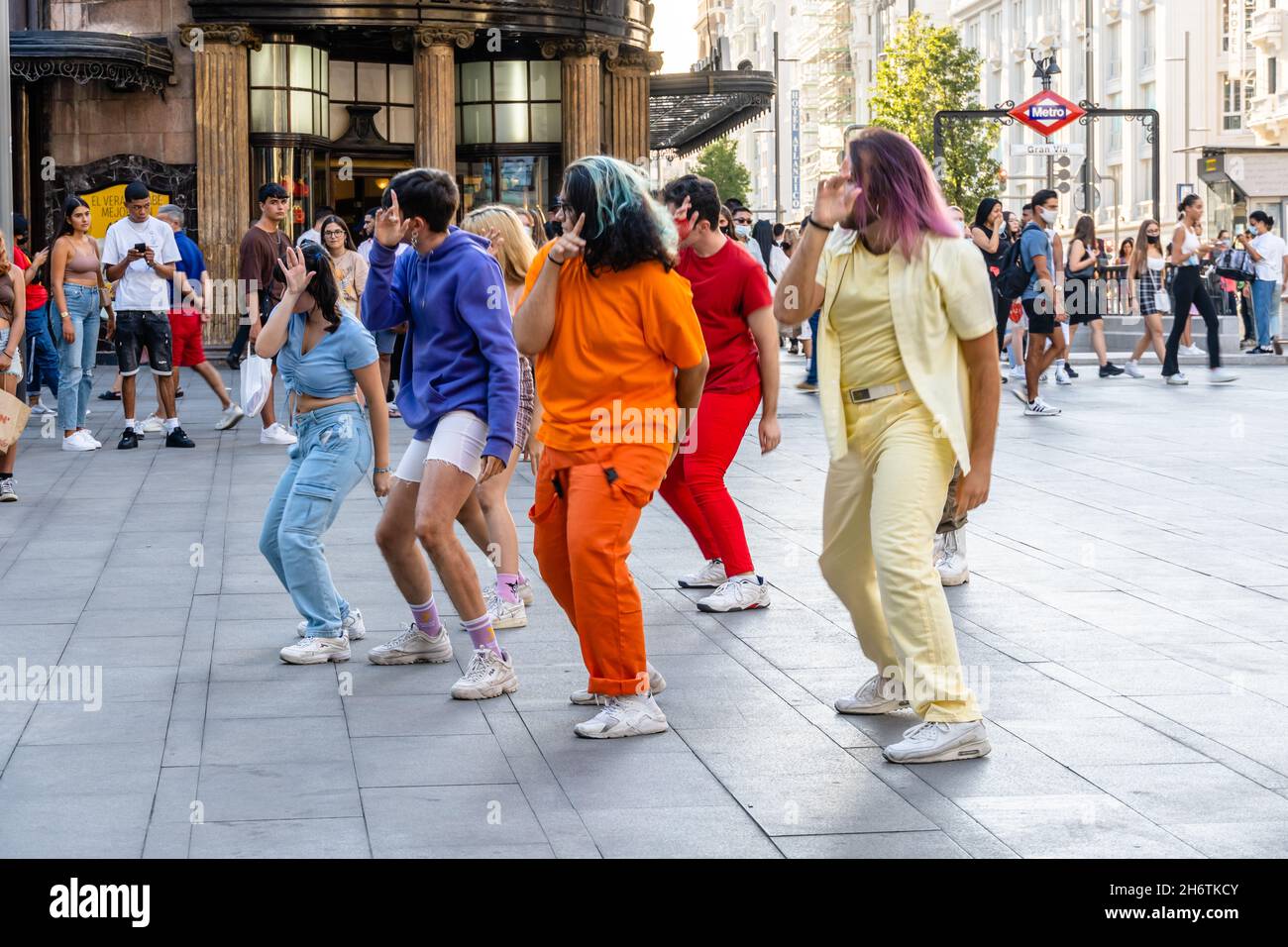 Madrid, Espagne - 31 août 2021 : groupe de jeunes adultes dansant dans la rue Gran via.Ils portent des vêtements colorés Banque D'Images