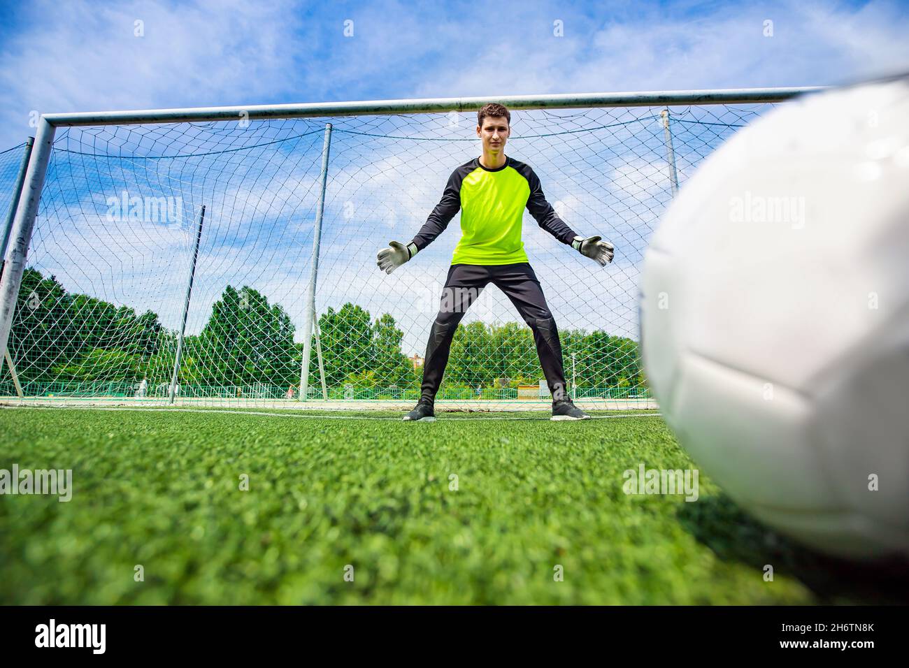 Homme de football joueur gardien de but attrapant le ballon à la pénalité. Banque D'Images