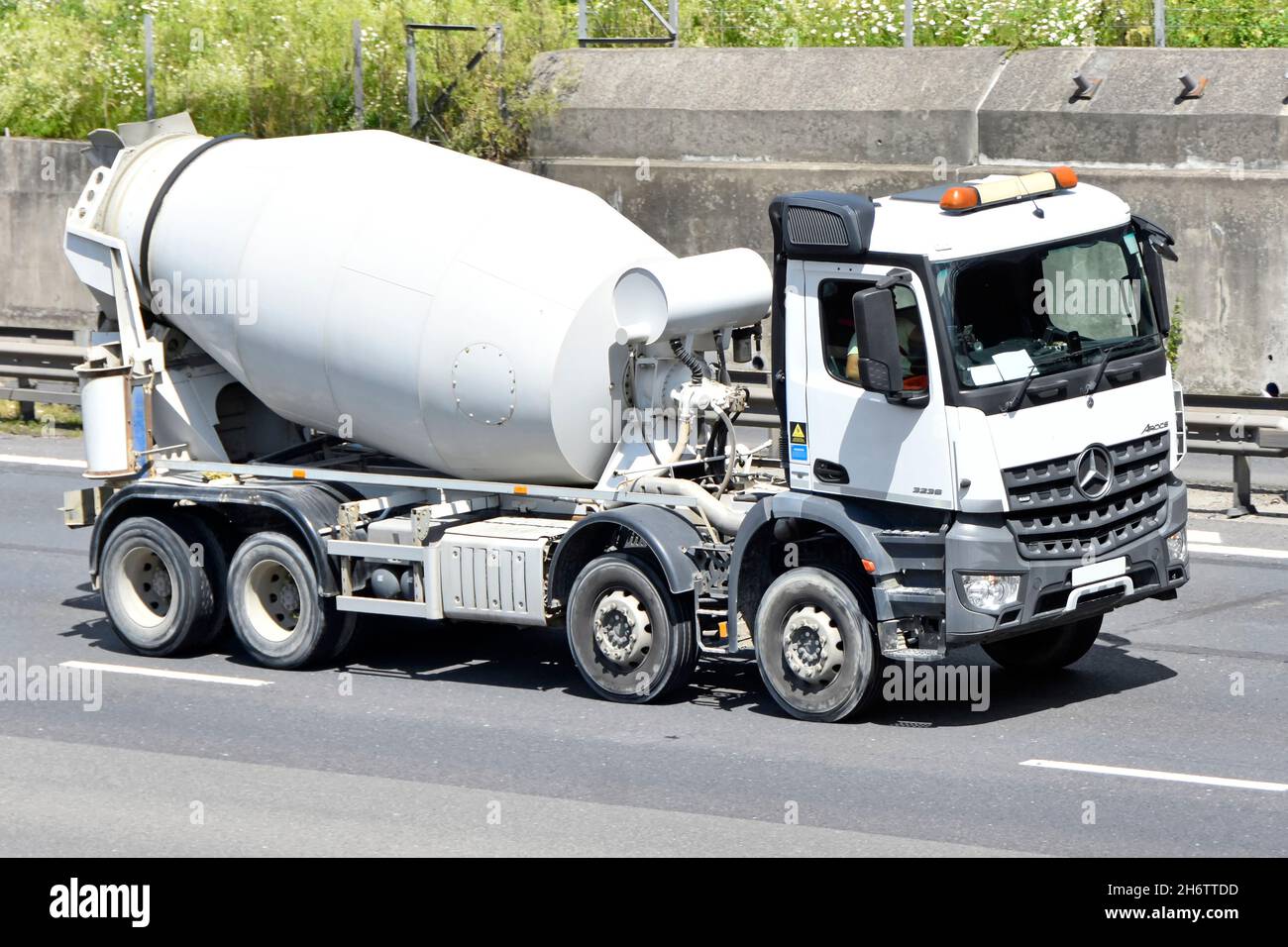 Vue latérale et avant blanc propre livraison camion Mercedes châssis-cabine équipé d'un conducteur de batteur à ciment prêt à l'emploi sur autoroute du Royaume-Uni Banque D'Images