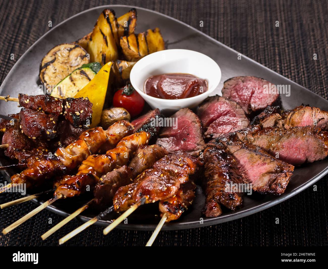 assiette à viande, ensemble de brochettes grillées et filet mignon grillé  sur une assiette servie avec des légumes grillés, gros plan sur un dos  sombre Photo Stock - Alamy