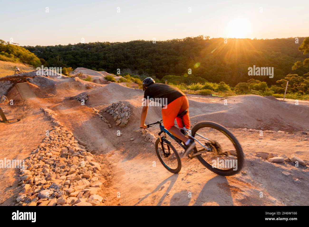 Un jeune cycliste qui surmonte la crête d'une pente abrupte, colline au parc de vélo Jubilee Oval à Wahroonga, Sydney, Nouvelle-Galles du Sud, Australie Banque D'Images