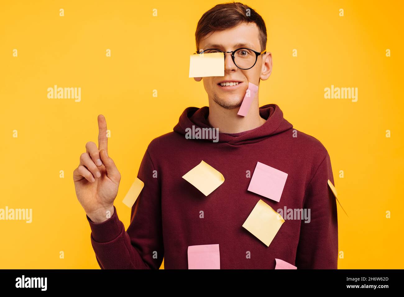 homme étudiant en lunettes sur fond jaune, collé avec des  autocollants.Autocollants pour le visage et le corps, homme concentré au  travail et à l'étude. Espace de copie, emplacement pour le texte Photo