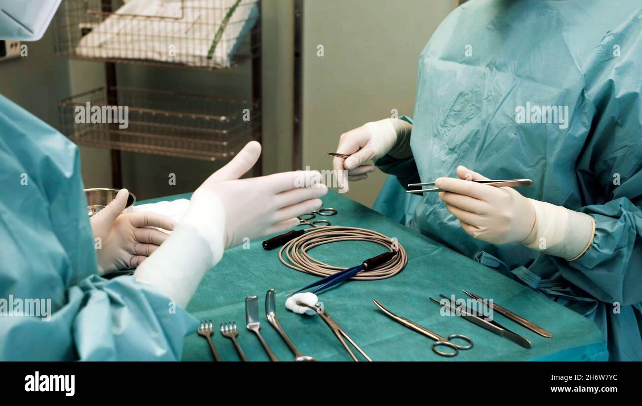 gros plan d'un médecin enseignant à un étudiant en médecine comment tenir correctement les instruments chirurgicaux Banque D'Images