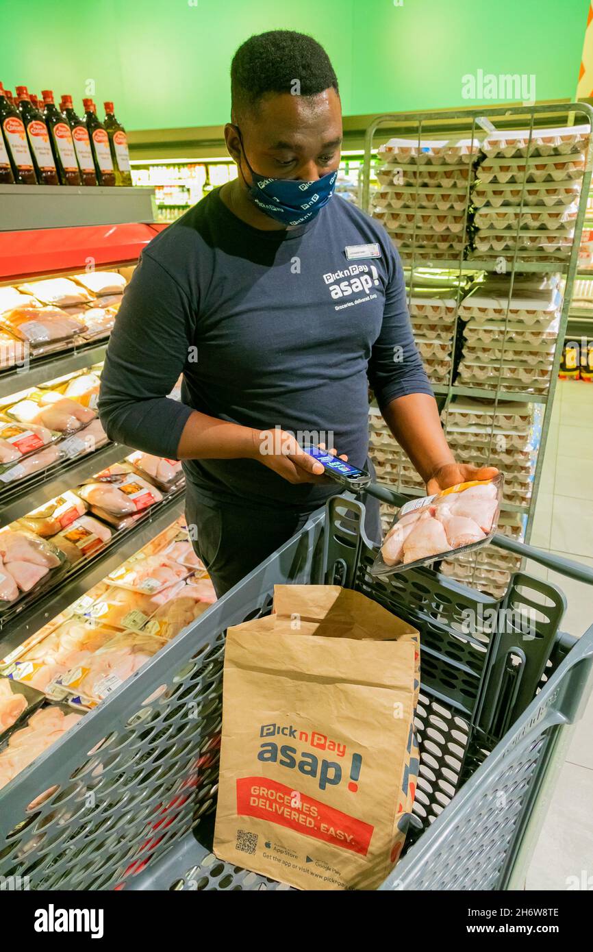 Cape Town, Afrique du Sud - 9 septembre 2021 : un membre du personnel cueille des produits à partir de l'étagère pour un service de livraison express à domicile Banque D'Images