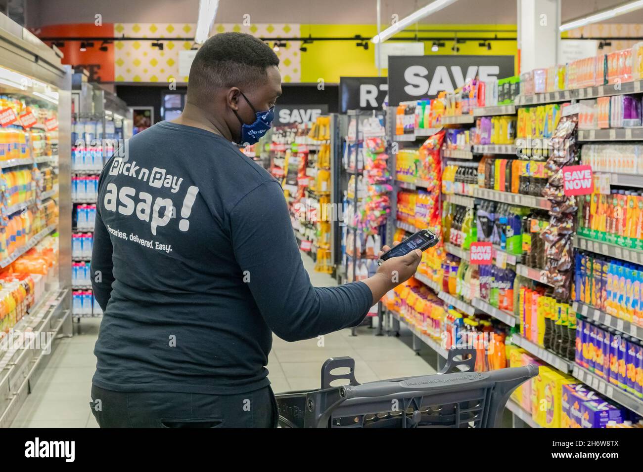 Cape Town, Afrique du Sud - 9 septembre 2021 : un membre du personnel cueille des produits à partir de l'étagère pour un service de livraison express à domicile Banque D'Images