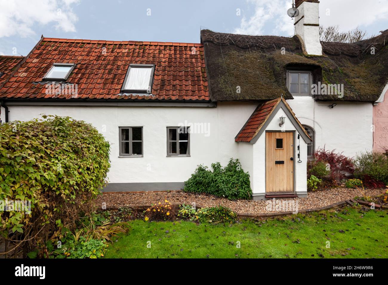 Kedington, Suffolk, novembre 19 2019 : cottage britannique traditionnel et pittoresque en Angleterre.Toit de chaume et de tuiles avec porche d'entrée et jardin. Banque D'Images