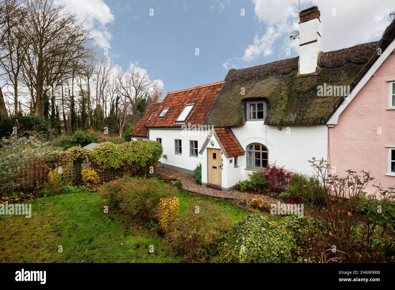 Kedington, Suffolk, novembre 19 2019 : cottage britannique traditionnel et pittoresque en Angleterre.Toit de chaume et de tuiles avec porche d'entrée et jardin. Banque D'Images